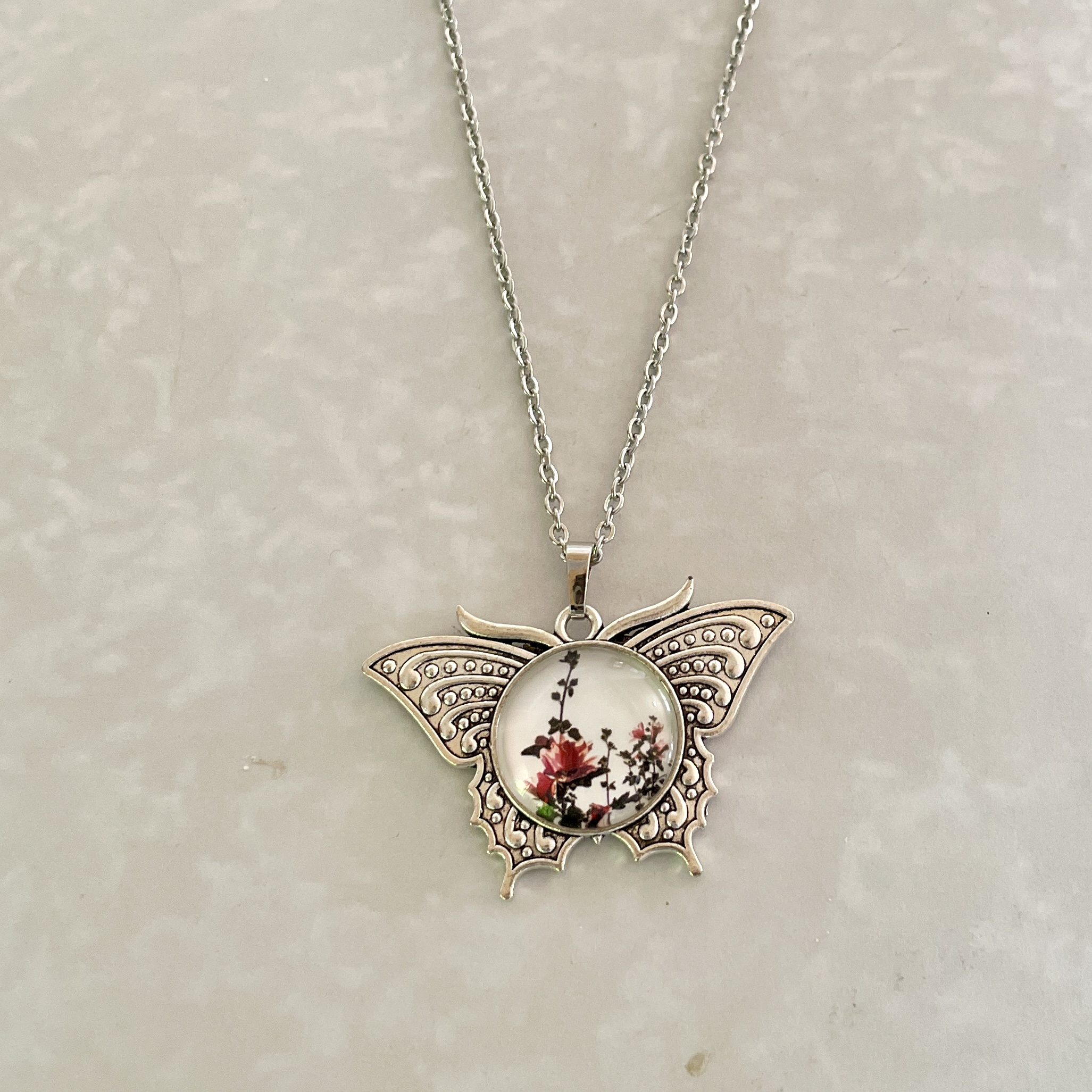 Silver butterfly necklace with floral pendant