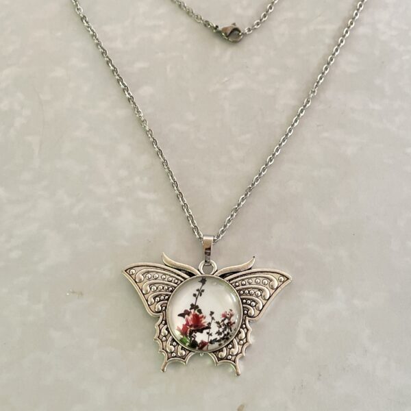 Silver butterfly pendant necklace with floral cabochon