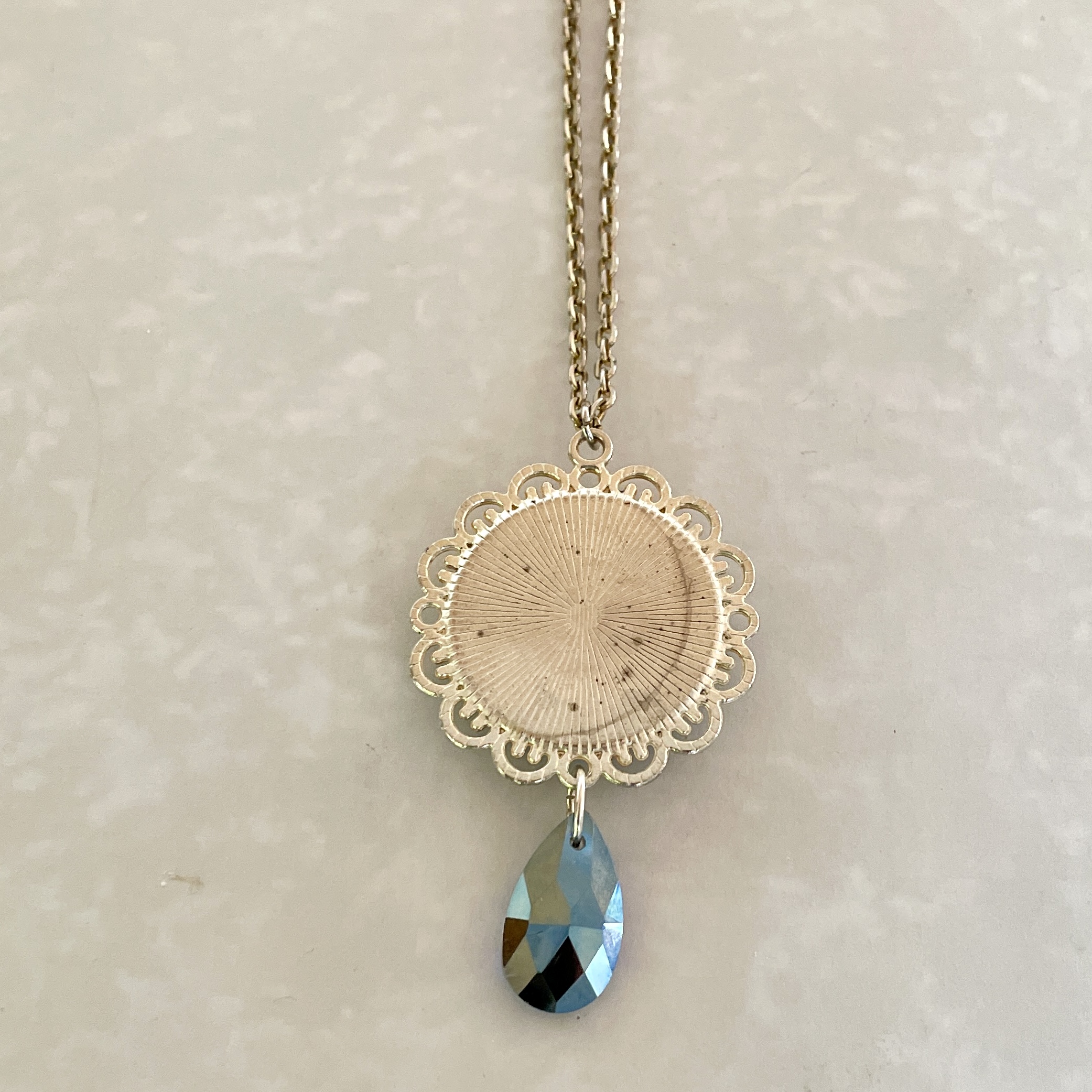 Gold filigree pendant with blue crystal teardrop