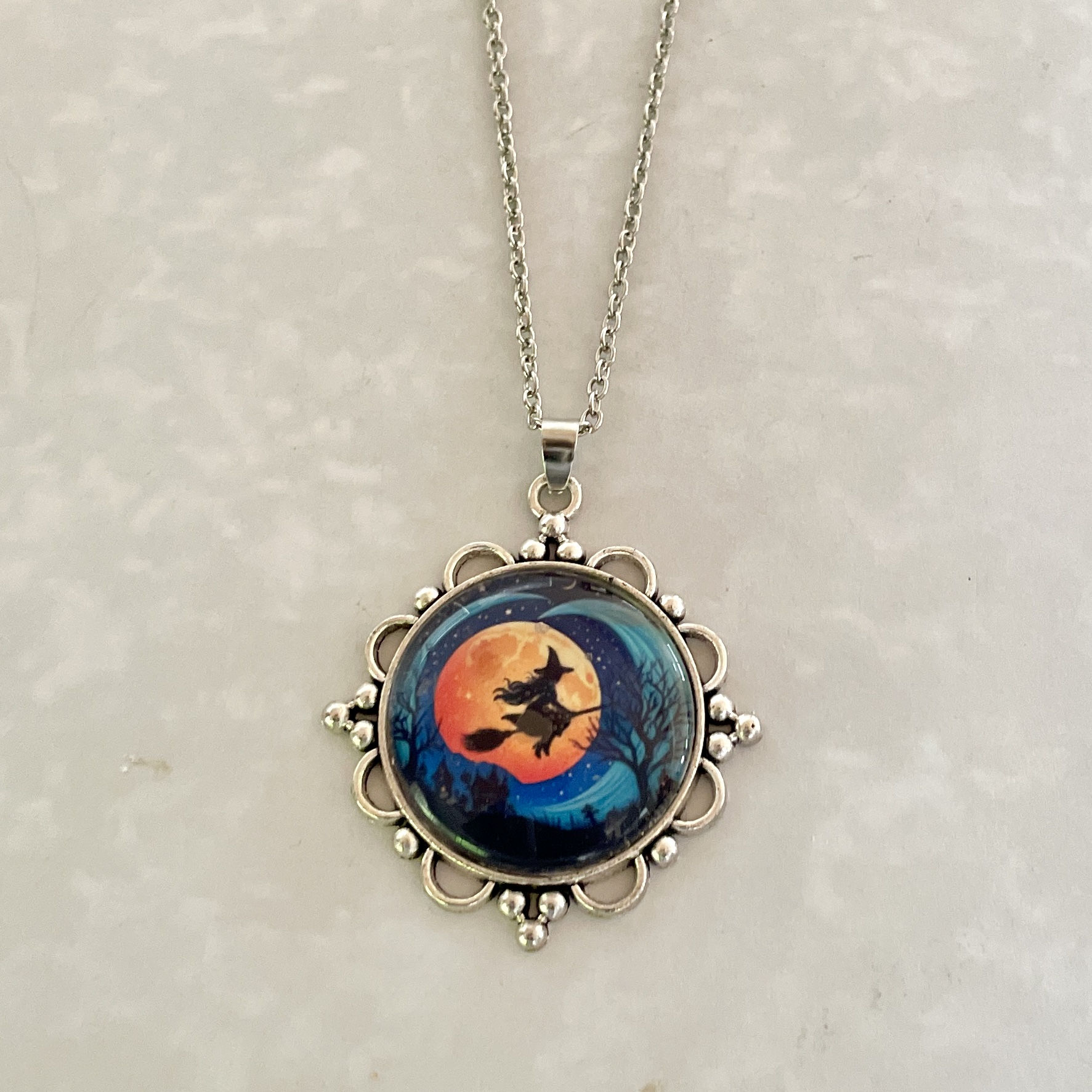 Silver pendant necklace depicting witch on broomstick