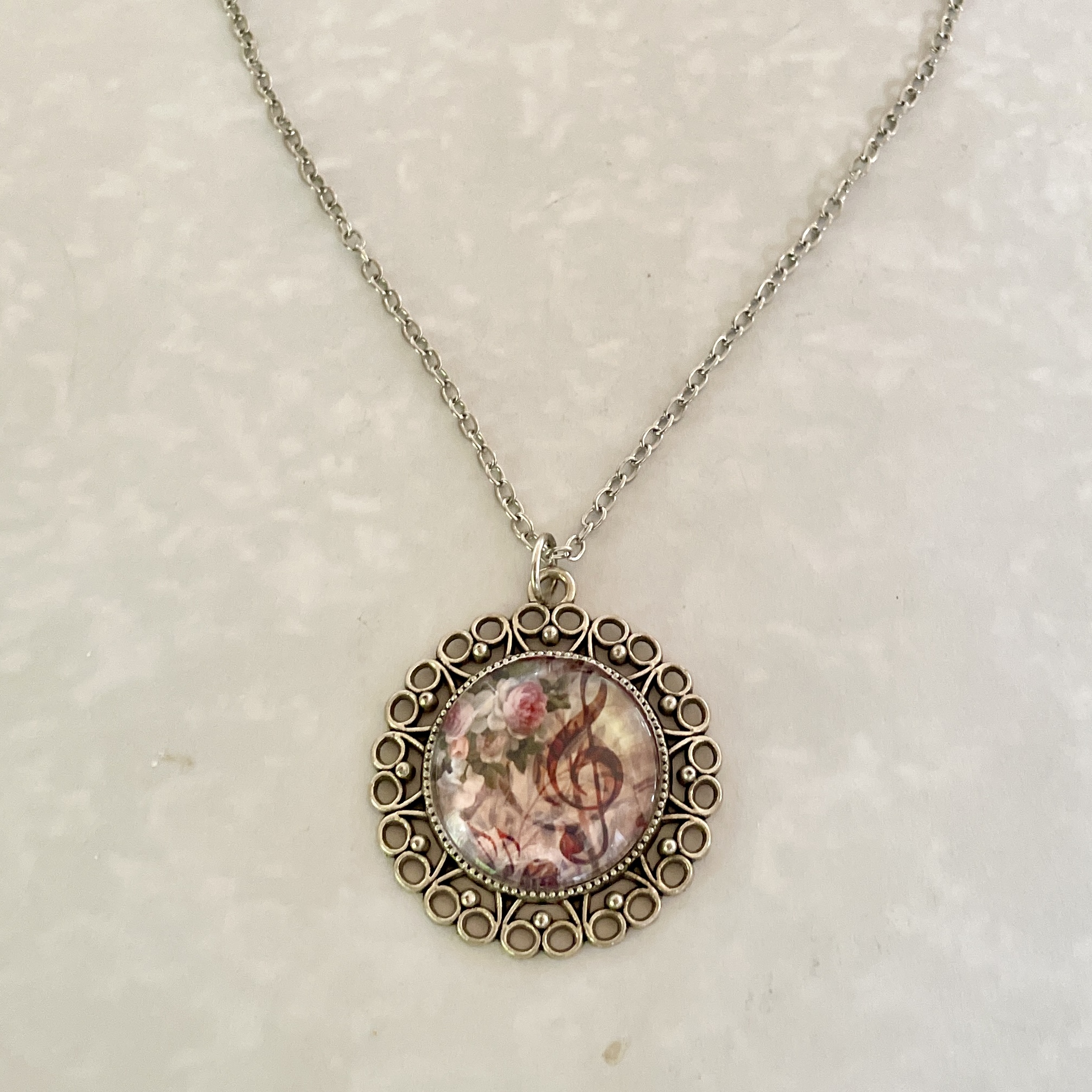 Ornate filigree floral treble clef pendant necklace