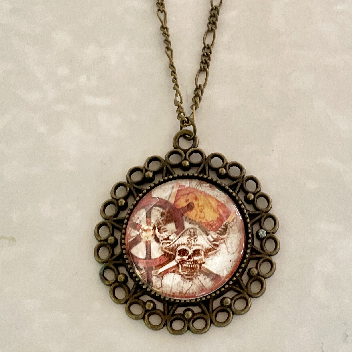 Bronze filigree pendant with skull-and-crossbones design
