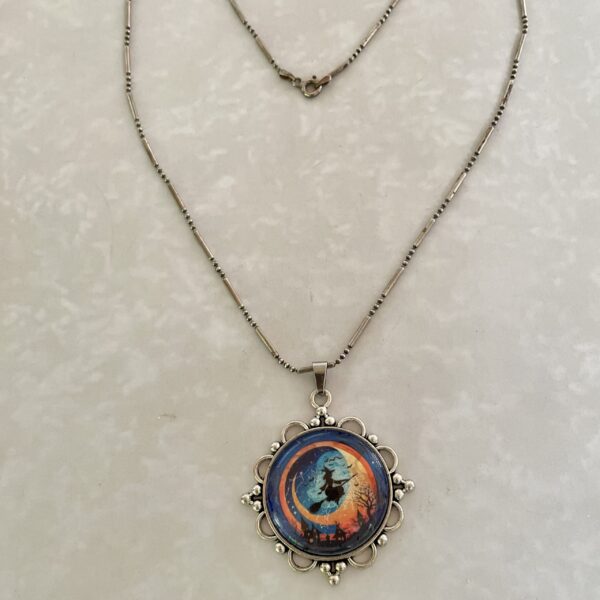 Ornate silver necklace with witch silhouette pendant