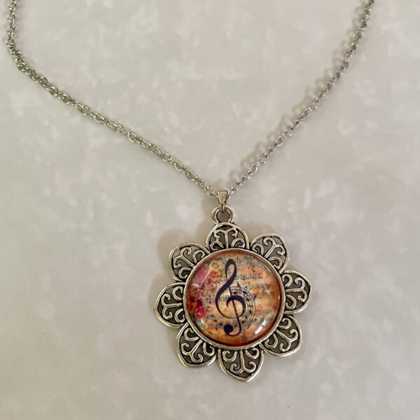 Silver floral pendant necklace with treble clef