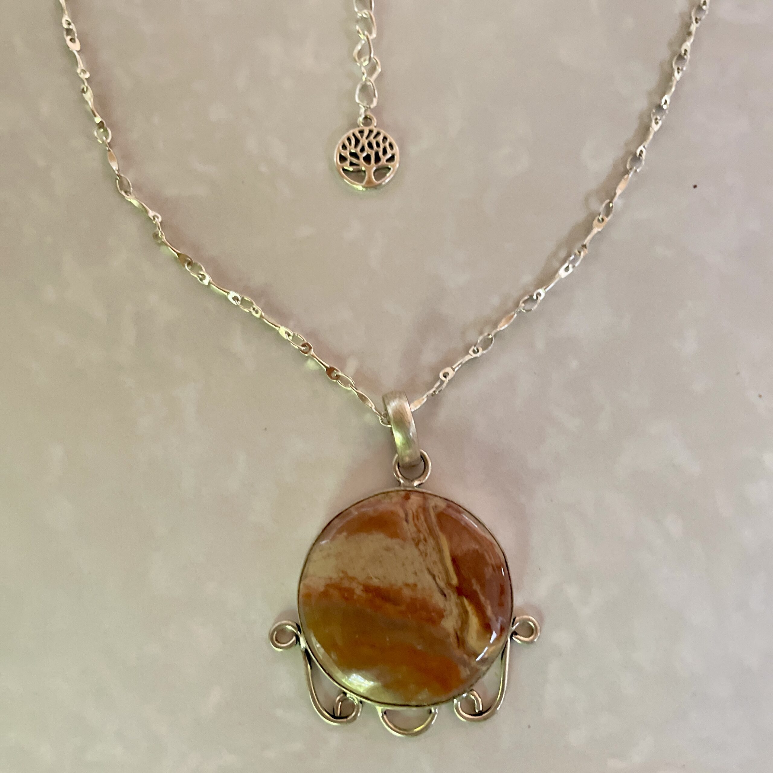 Elegant necklace featuring a round stone pendant.