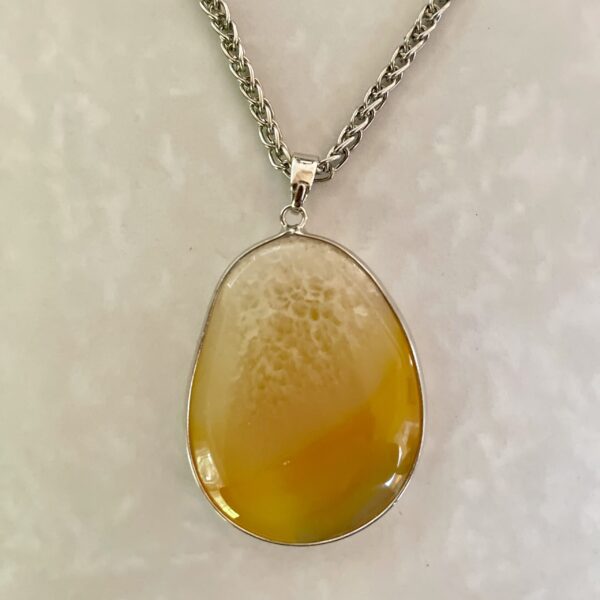 Elegant yellow pendant on silver chain.