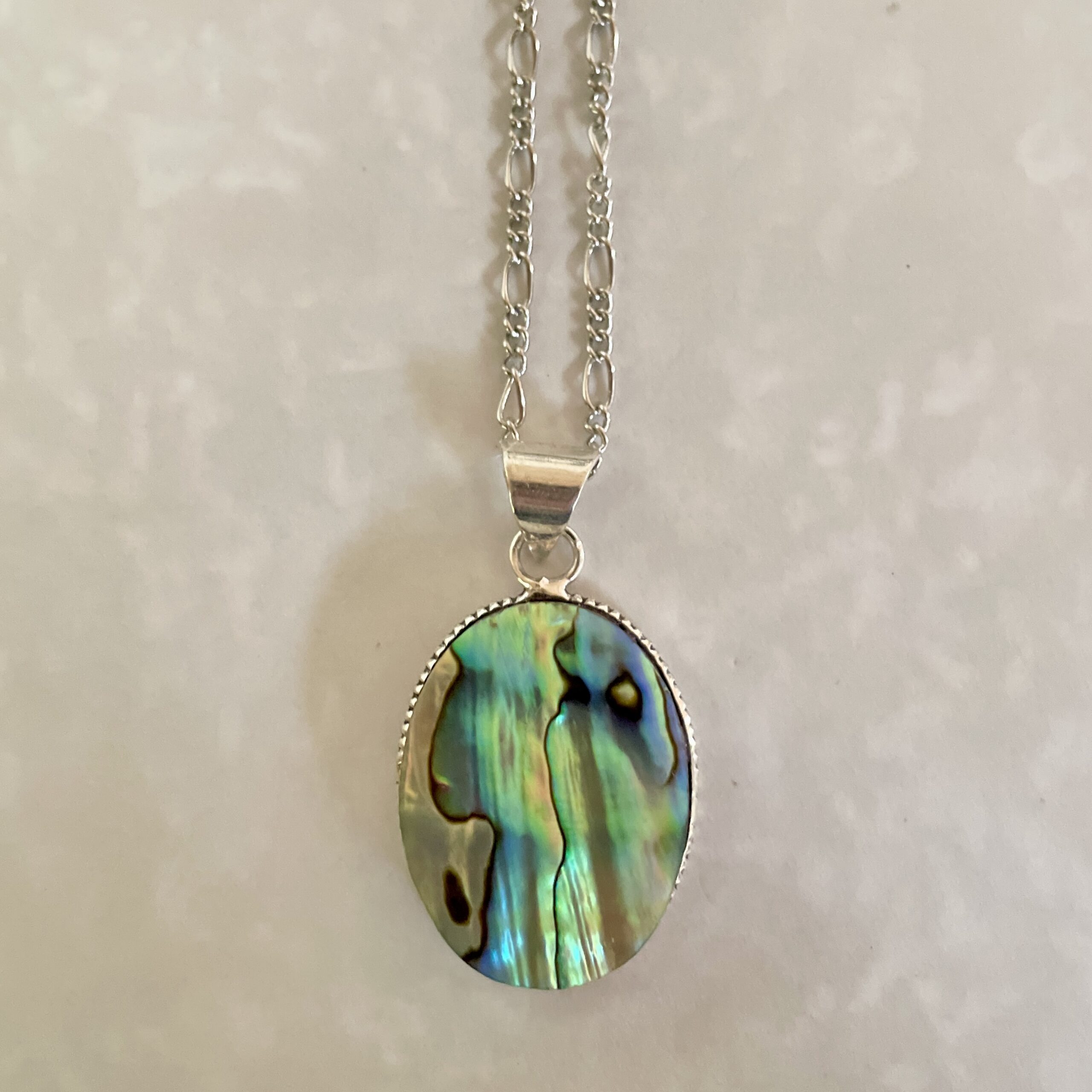 Colorful oval pendant on silver chain.