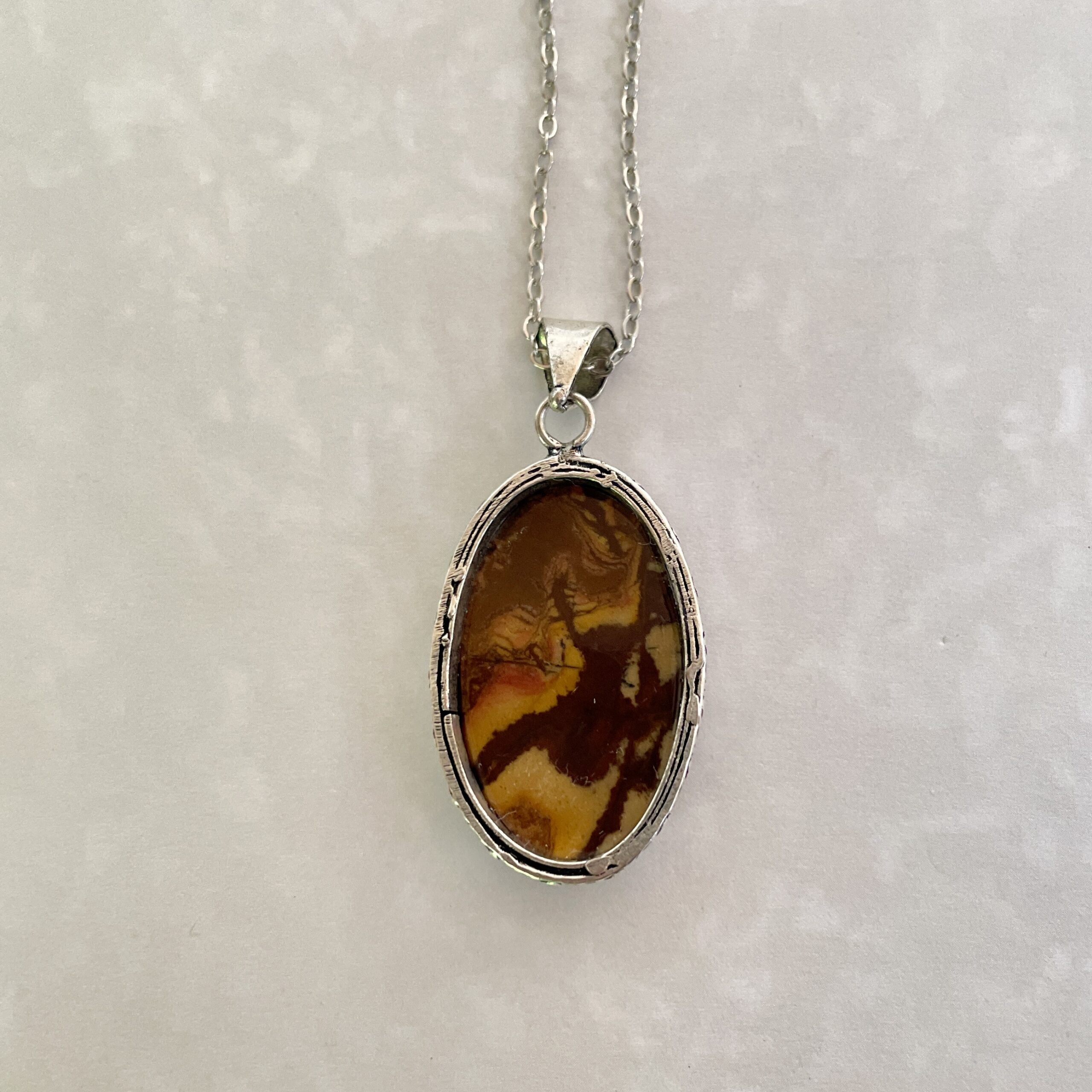 Stylish pendant with a marbled brown stone.