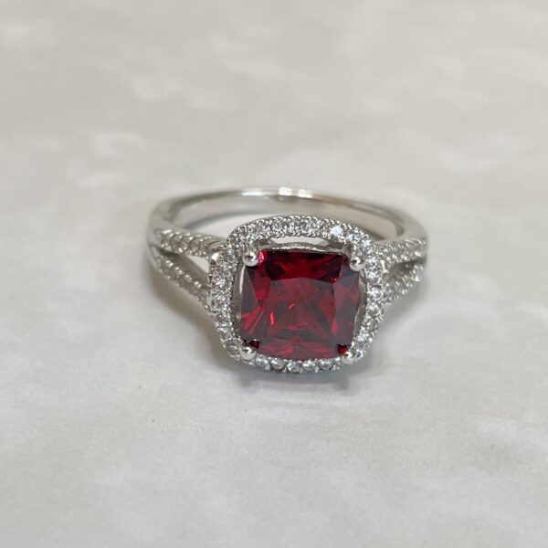 Elegant ring featuring a large red gemstone.