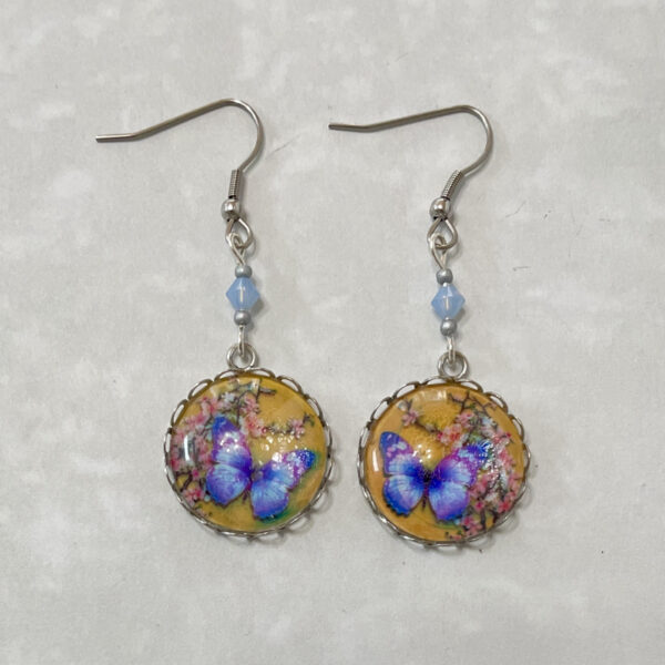 Blue butterfly dangle earrings with floral background
