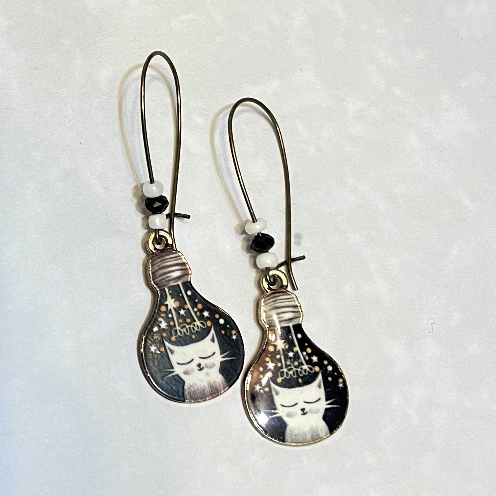 Whimsical cat-themed lightbulb earrings design.