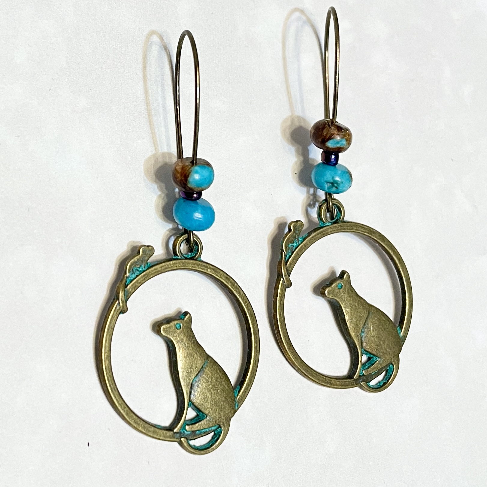 "Bronze cat earrings with turquoise beads"