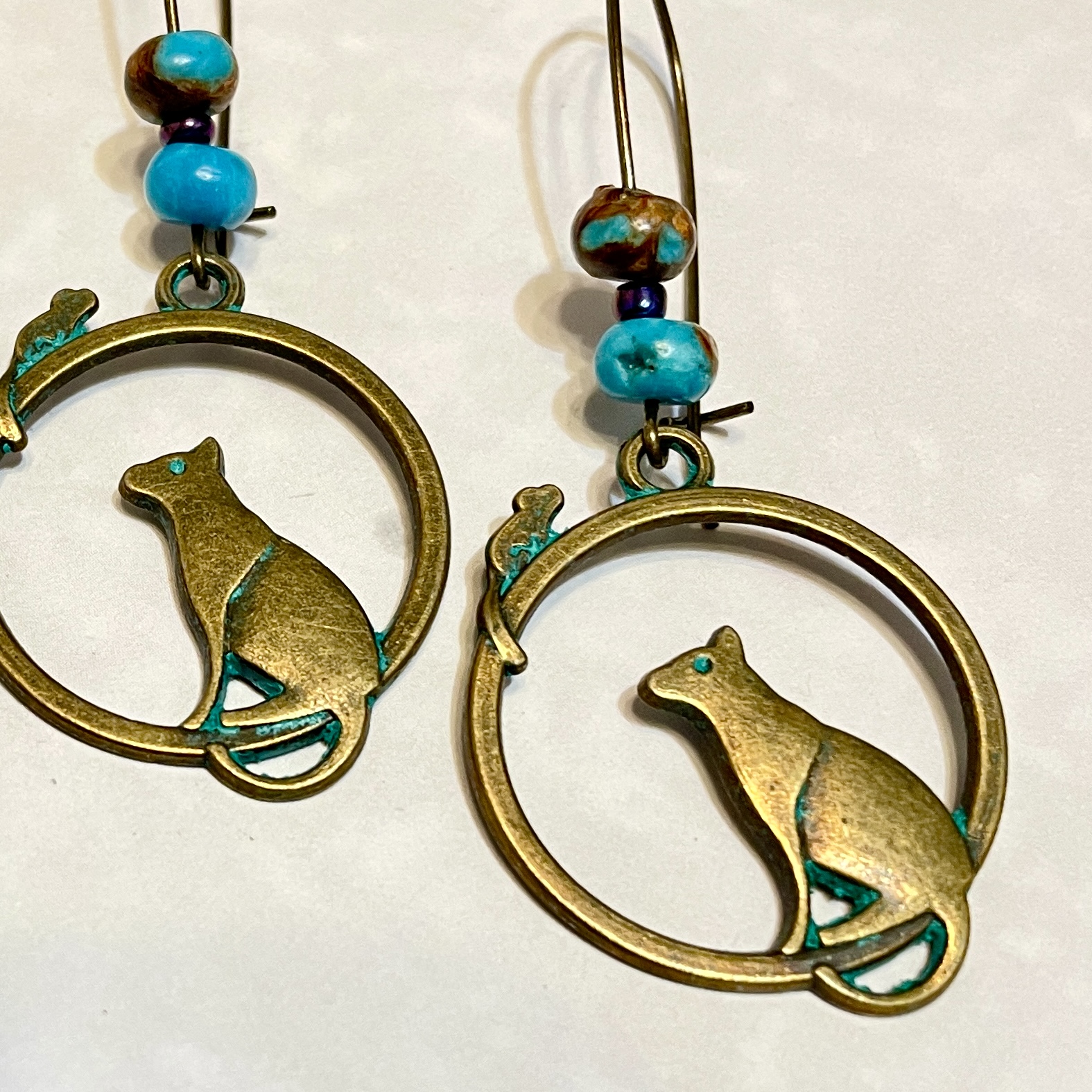 Bronze cat earrings with turquoise accents.