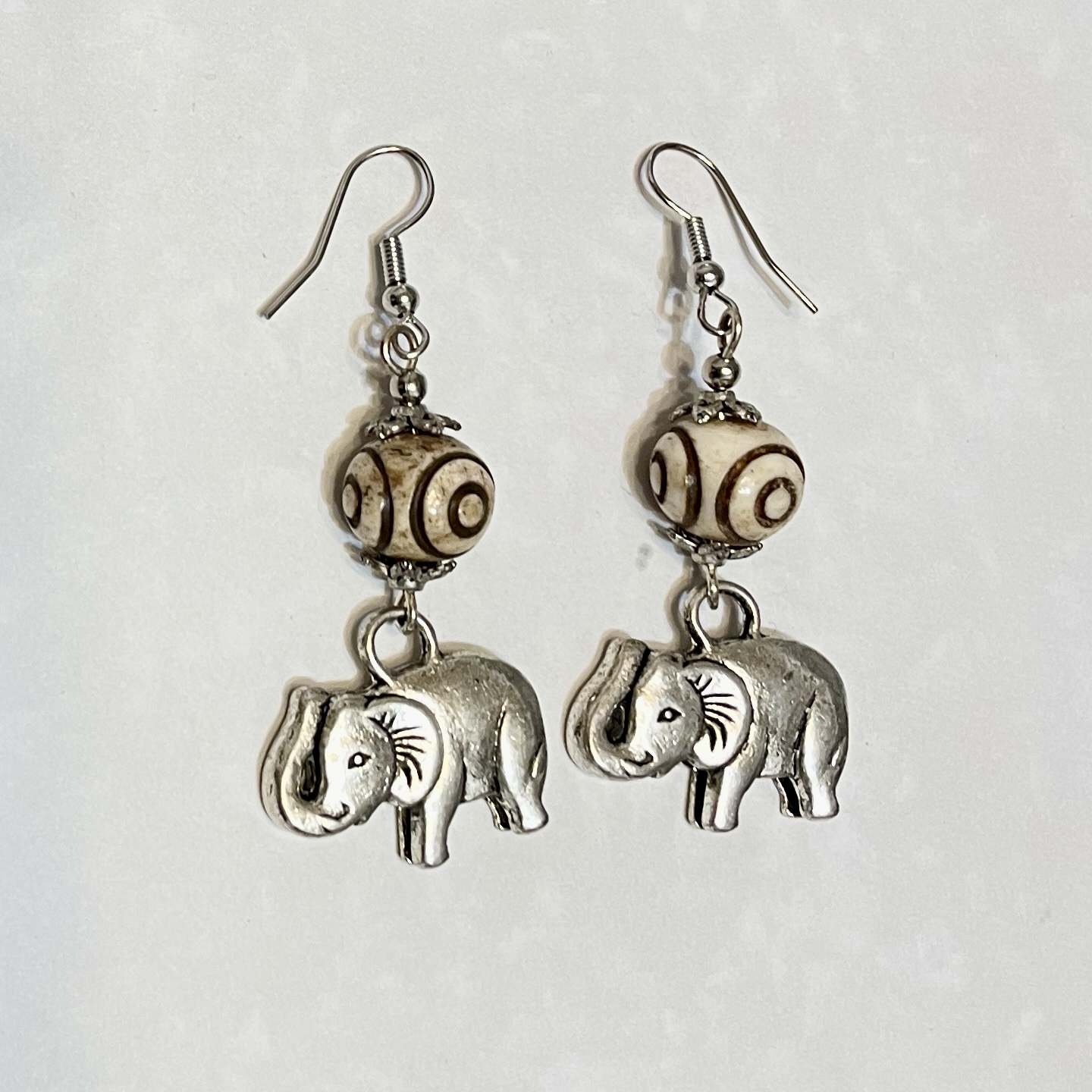 Elephant earrings with decorative patterned beads.