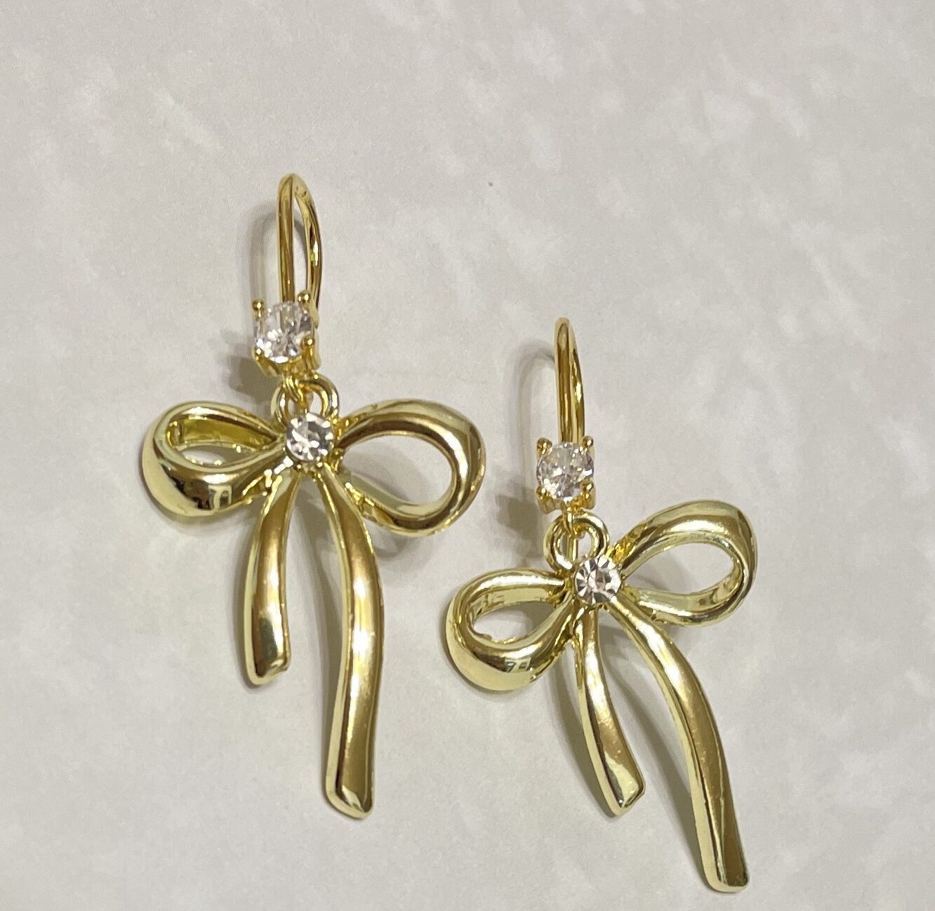 Gold bow earrings with sparkling crystal accents.