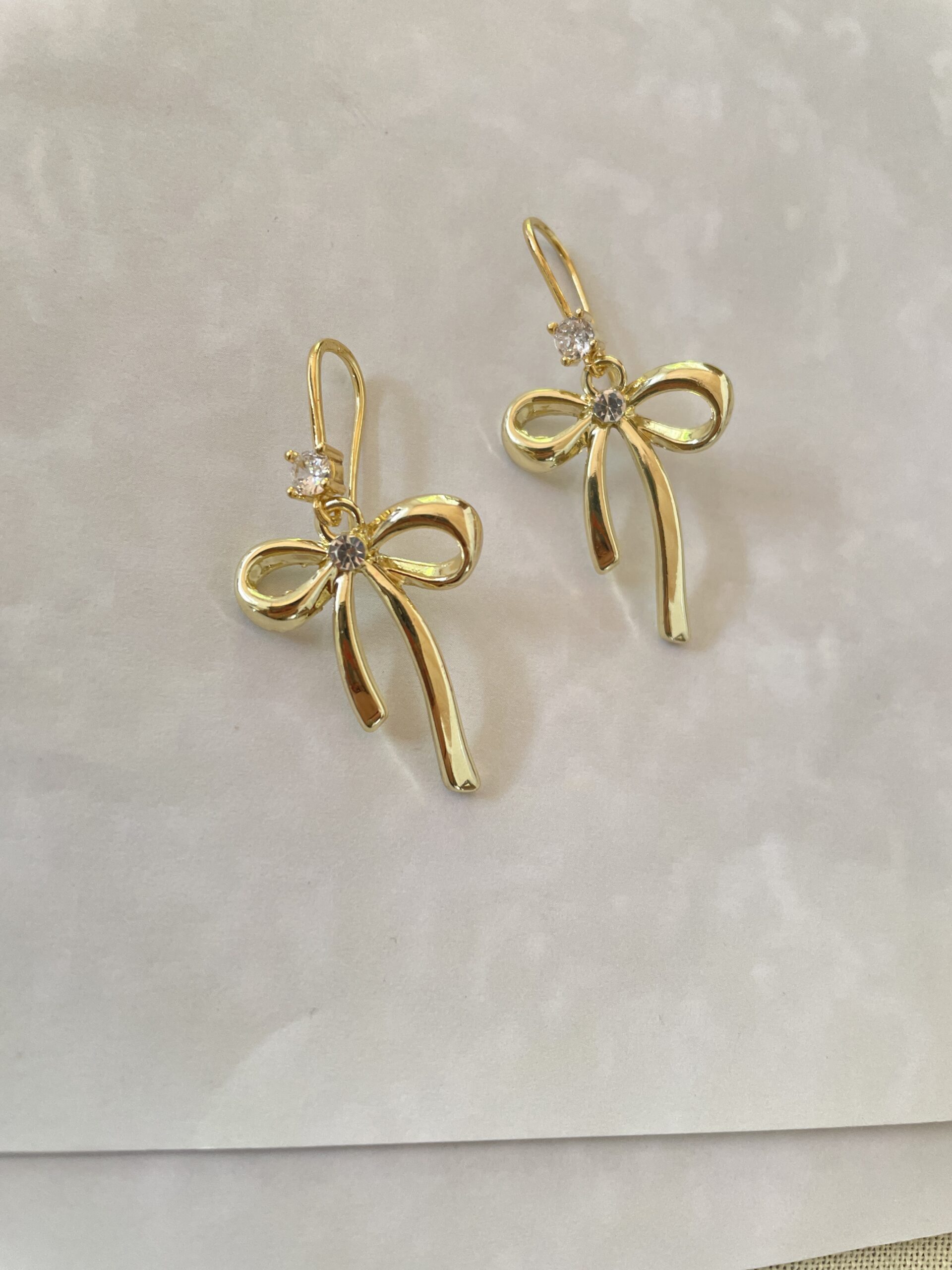 Gold bow earrings with sparkling accents.