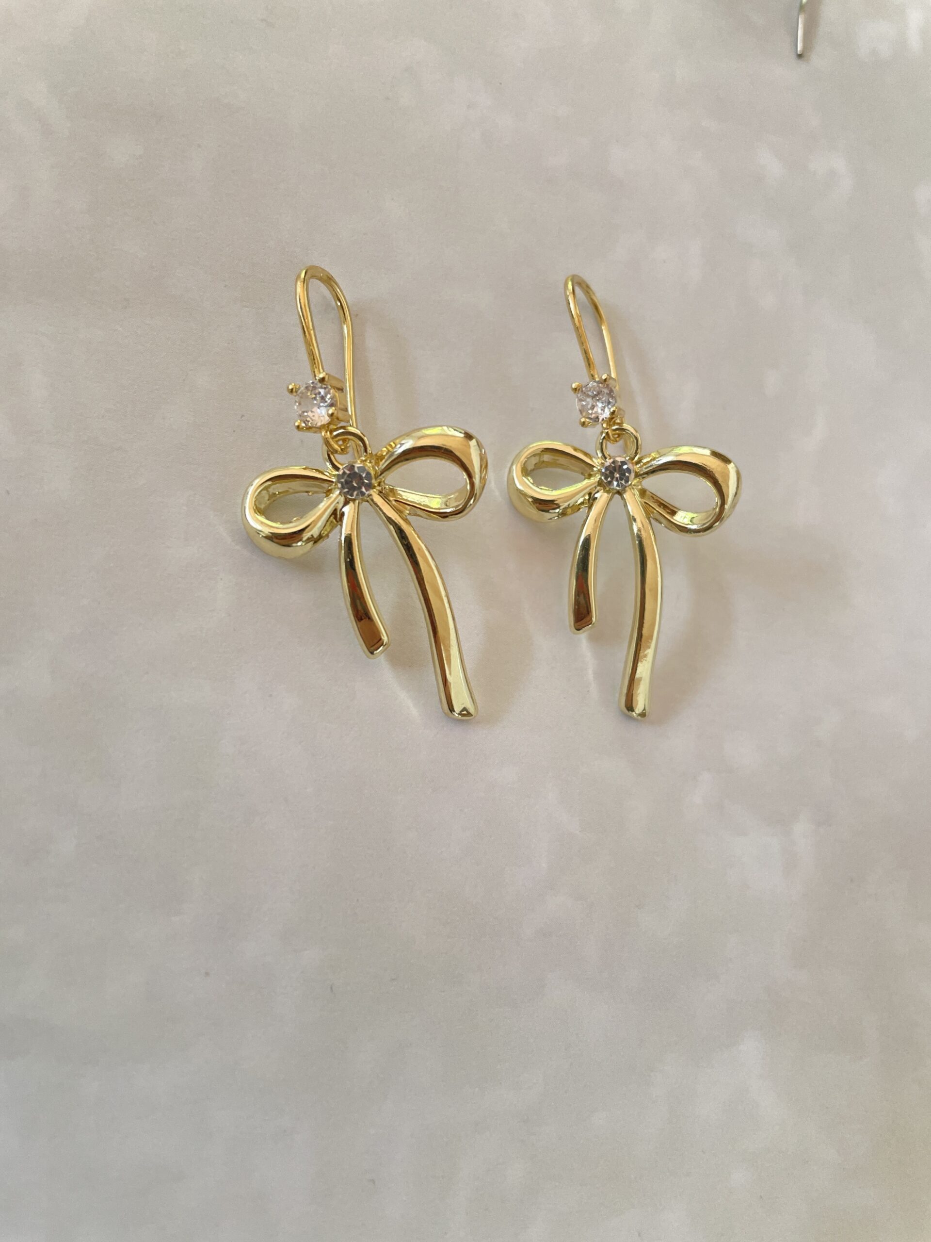 Gold bow-shaped earrings with sparkling accents.