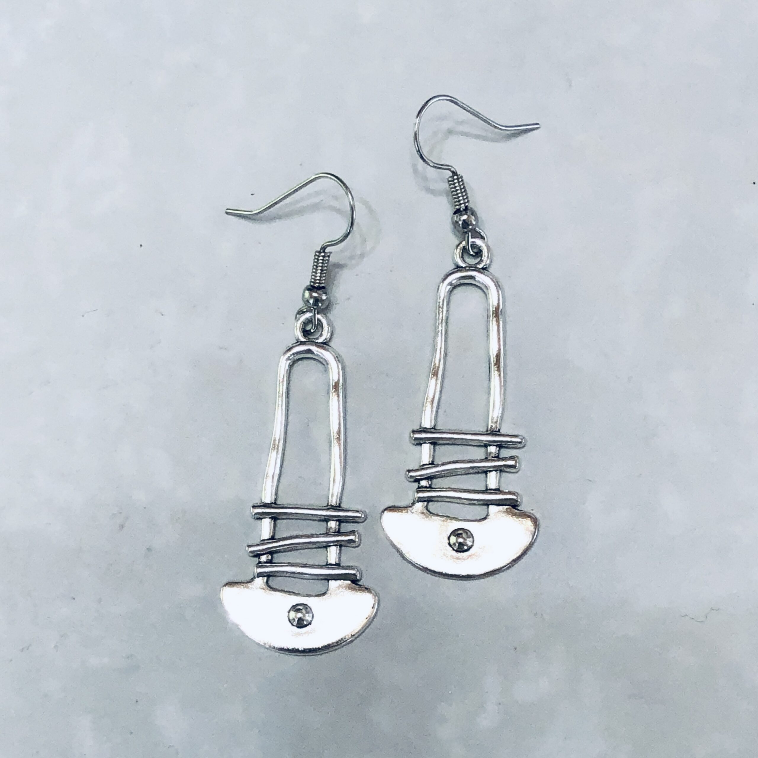 Silver earrings designed like safety pins.
