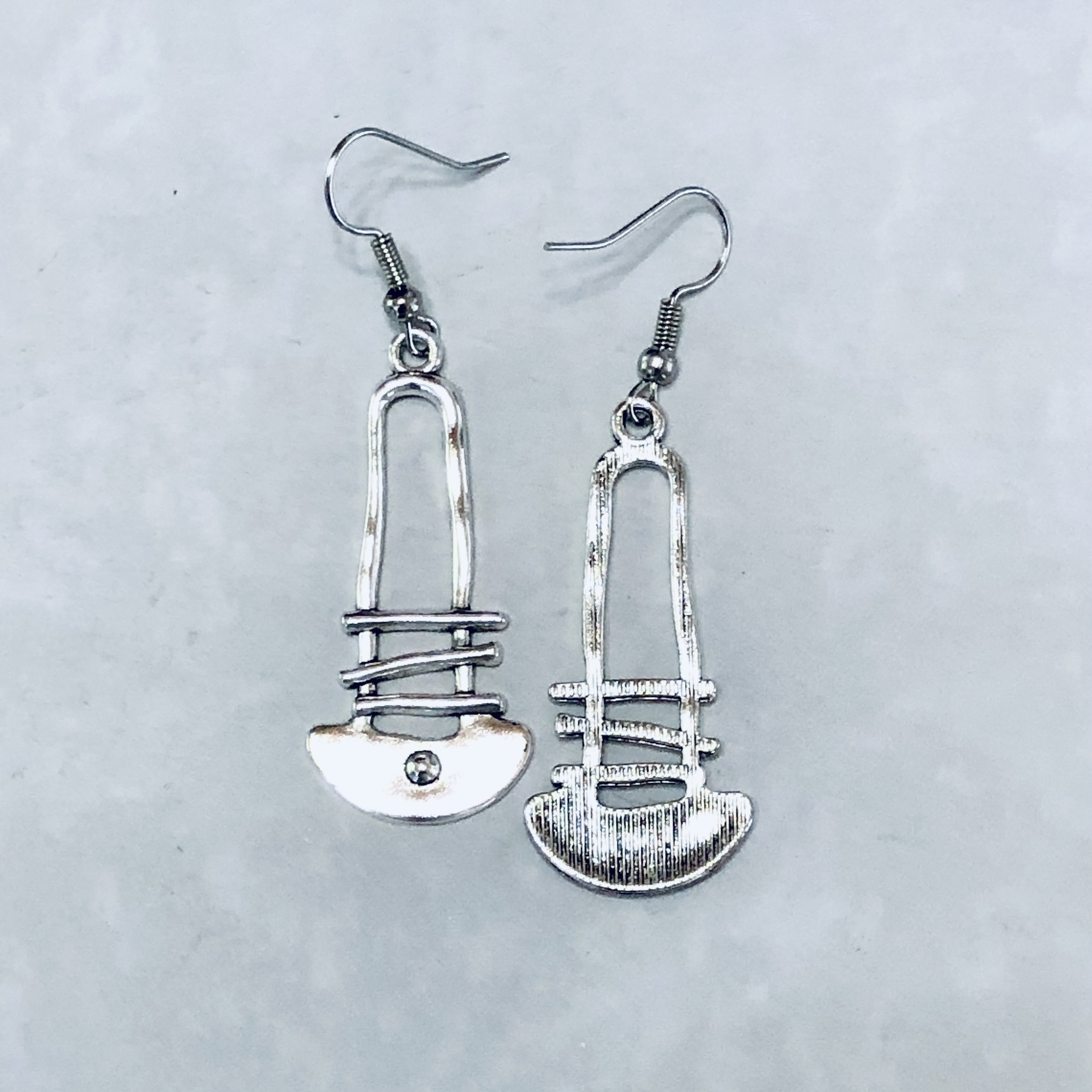 Unique silver earrings shaped like safety pins.